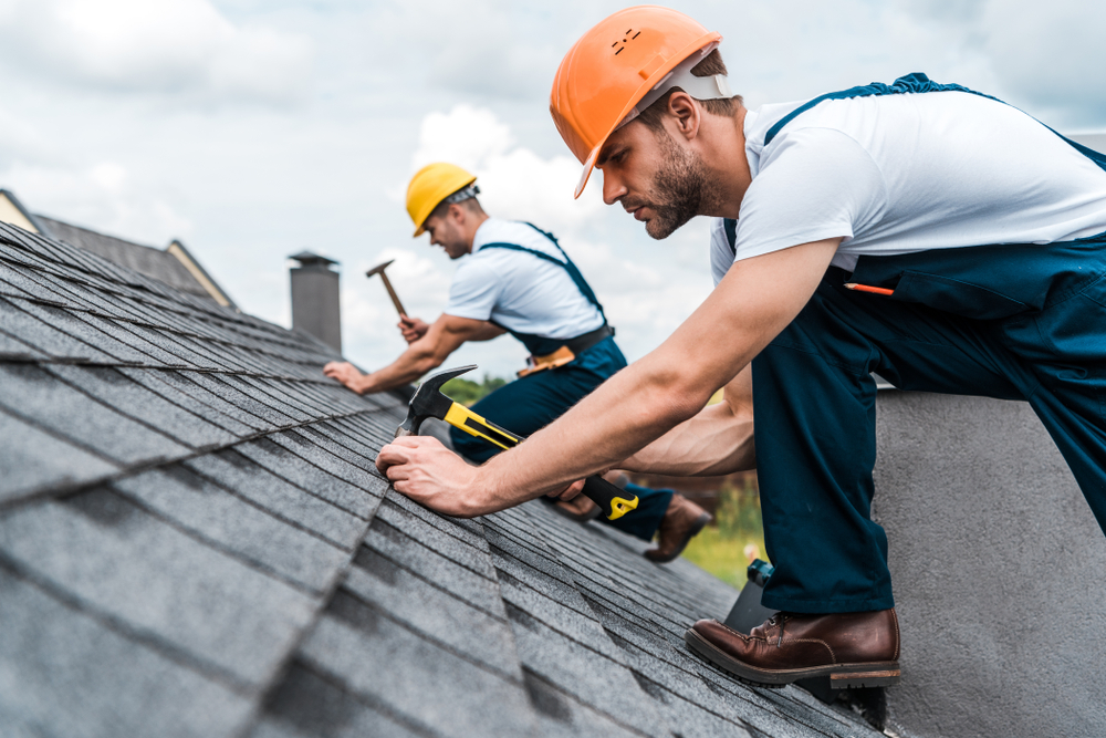 Selective,Focus,Of,Handsome,Handyman,Repairing,Roof,With,Coworker