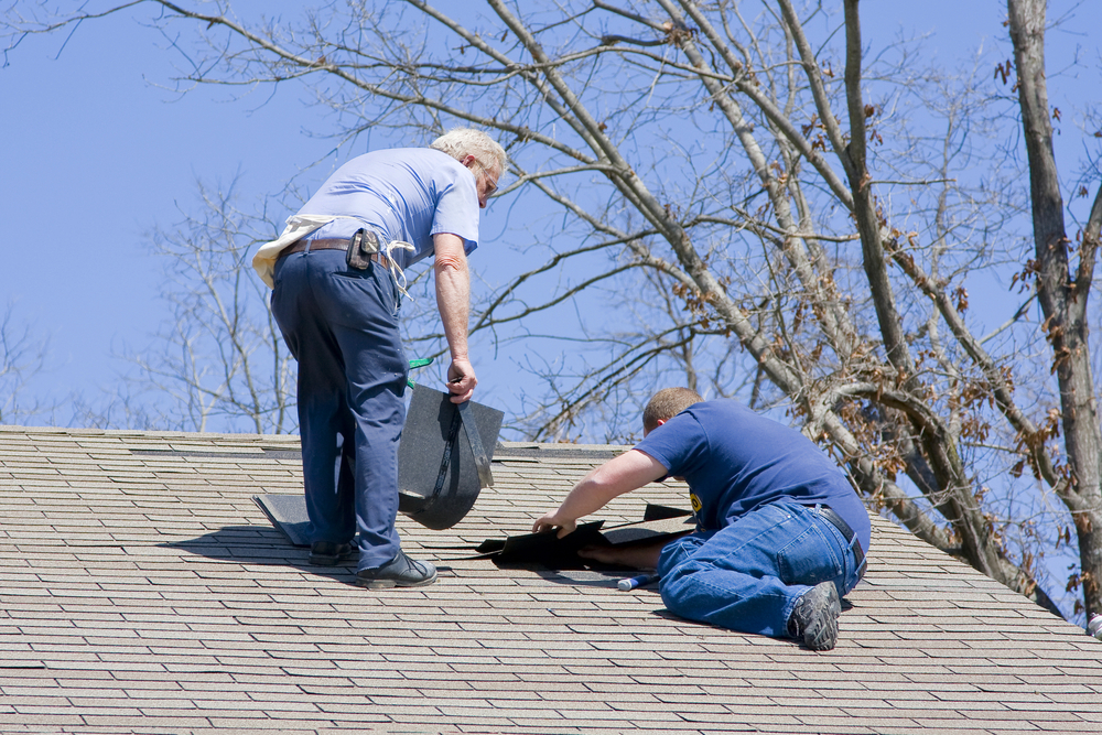 Roofing,Contractor,Repairing,Damaged,Roof,On,Home,After,Recent,Wind
